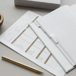 Un bolígrafo con una ficha para organizar las finanzas y una agenda.